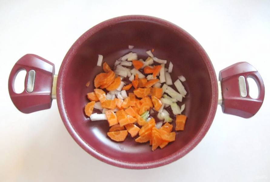 Одну луковицу и морковь очистите, помойте и нарежьте произвольно. Выложите в кастрюлю с антипригарным покрытием или сковороду.