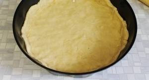 Раскатать тесто, выложить в форму, сделать бортики. Наколоть тесто вилкой или насыпать фасоль, поставить в нагретую духовку на 10-12 минут.