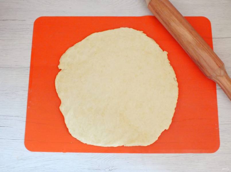 По истечении времени достаньте тесто из холодильника. Рабочую поверхность слегка подпылите мукой. Раскатайте тесто в пласт толщиной 0,5 см.