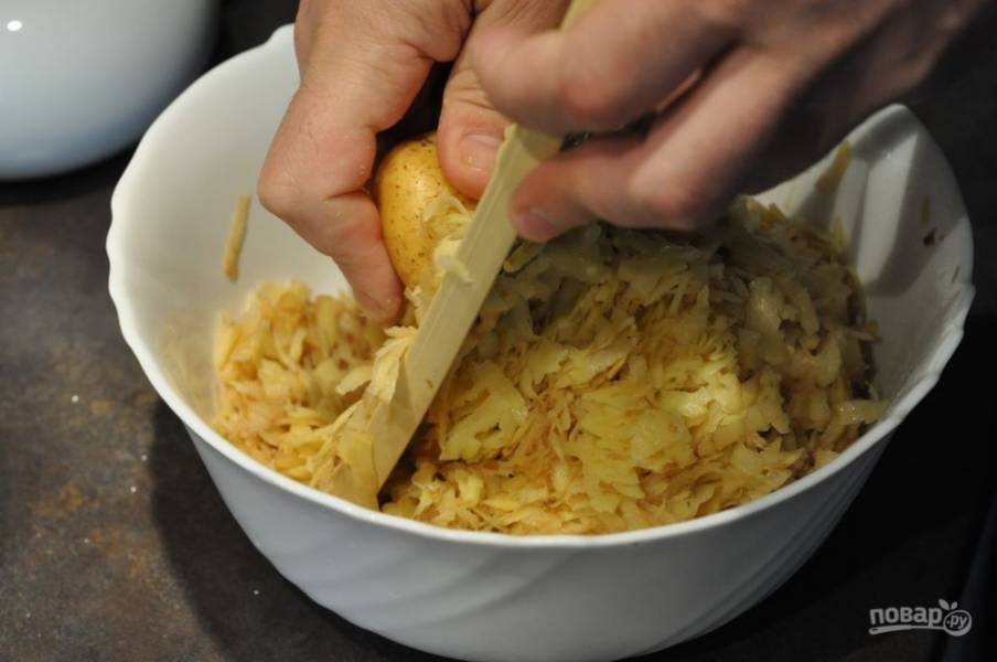 Теперь необходимо натереть картофель на терке. Если он молодой, то вы можете не очищать его от шкурки. После того как весь картофель будет подготовлен, отожмите его и слейте лишний сок. 