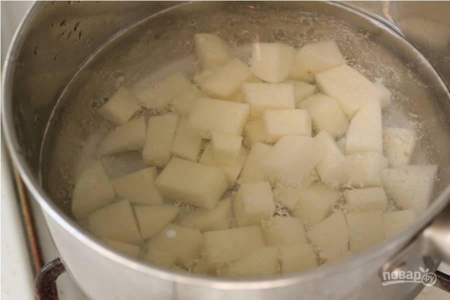 1.	Очистите картошку и нарежьте ее кубиками, поместите в кастрюлю и залейте холодной водой, отварите до готовности.