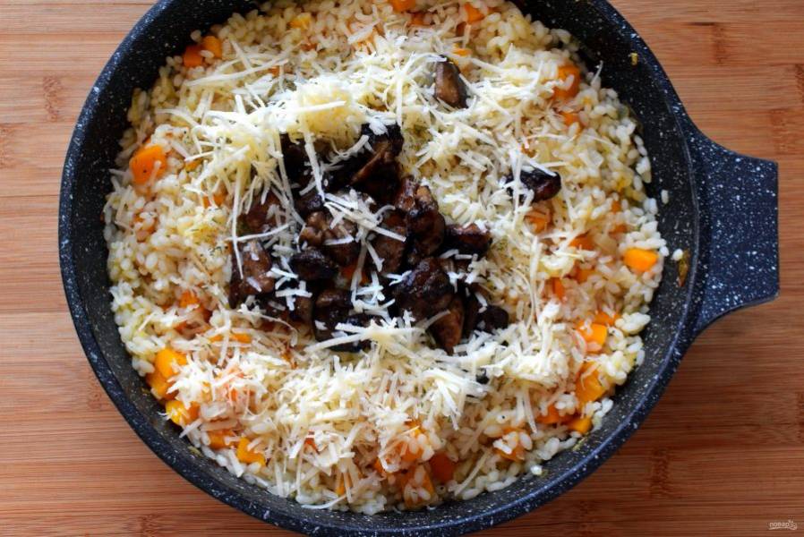 Минут через  20 попробуйте рис. Если он почти готов, добавьте в блюдо немного тимьяна, выложите жареные грибы и тертый пармезан. Перемешайте и снимите ризотто с огня, дайте настояться под крышкой минут 7.