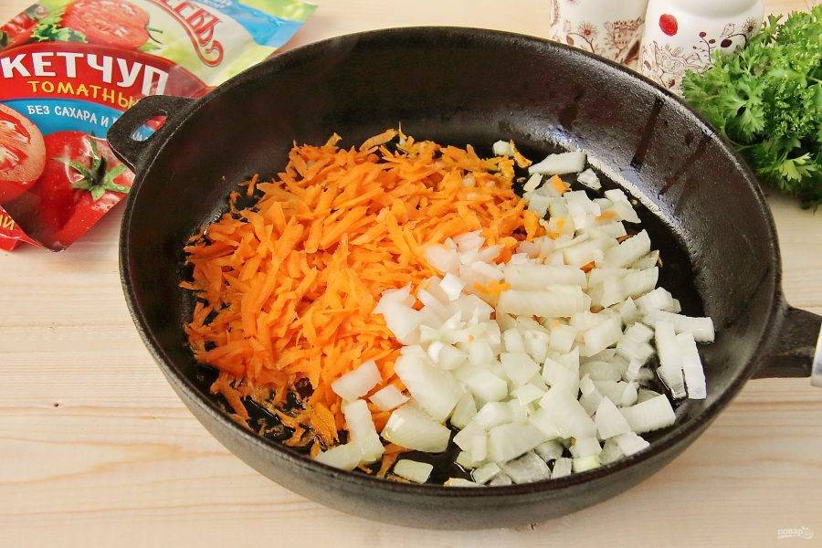 На сковороде разогрейте растительное масло и положите нарезанный кубиками лук и тертую морковь.