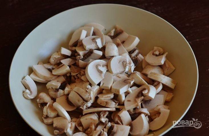 Возьмите любые свежие грибы, к примеру, подойдут шампиньоны. Они всегда доступны и продаются в каждом супермаркете. Замочите их в холодной воде, помойте и почистите. Нарежьте шампиньоны кусочками. 