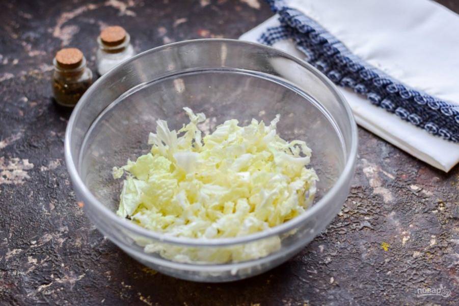 Китайскую капусту сполосните и просушите, нарежьте капусту тонкой соломкой и переложите в салатник.
