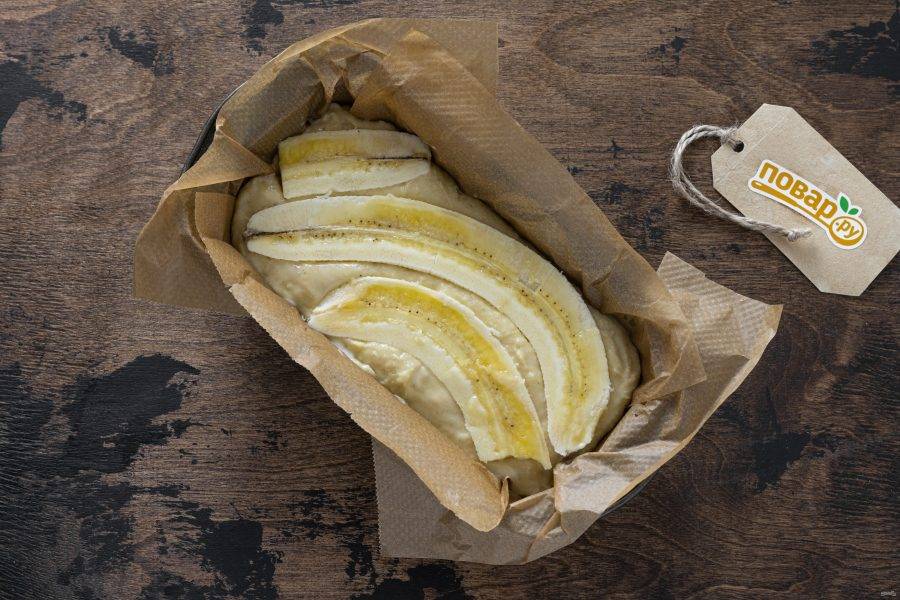 Выложите тесто в застеленную пергаментом форму для выпечки. Разрежьте 1 банан пополам и выложите сверху, слегка вдавив его в тесто. Выпекайте банановый хлеб в духовке 45-50 минут при температуре 180 градусов.