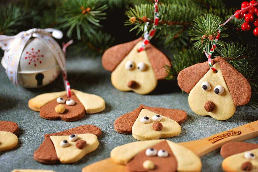 Готовое печенье остудите на решетке, проденьте в каждую дырочку цветную ленту, свяжите вверху. Этими собачками можно украсить новогоднюю елку.