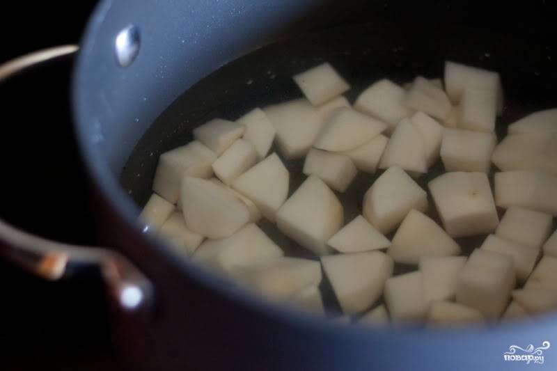 Как только вы закинули овощи в кастрюлю, залейте в отдельной кастрюльке картофель водой. Доведите до кипения, уменьшите огонь и варите, пока он не станет мягким.