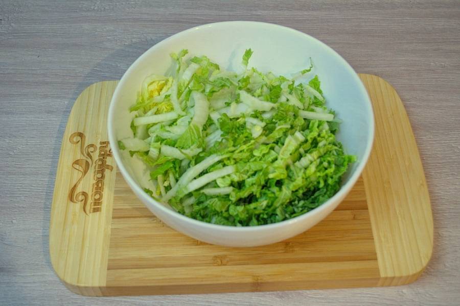 Для приготовления салата "Амброзия" мы возьмем пекинскую китайскую капусту. Капусту нужно вымыть, обсушить и нарезать тонкой соломкой. Если соломка получится слишком длинной, укоротите ее.