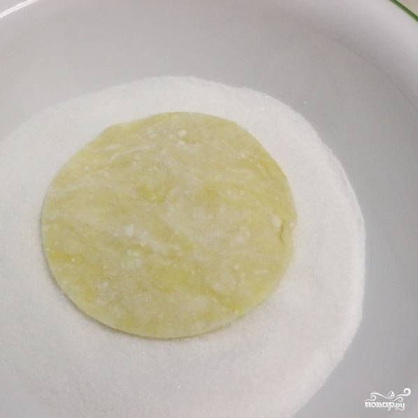 9. Приготовьте тарелку с сахаром. Одну сторону кружка из теста обмакните в сахар.