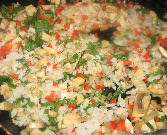 Разогрейте на сковороде сливочное масло, обжарьте измельченный лук, добавьте грибы и перец. Посолите и поперчите, а через несколько минут добавьте вареный рис и 1 ст.л. измельченной зелени. Тщательно перемешайте. Начинка готова!