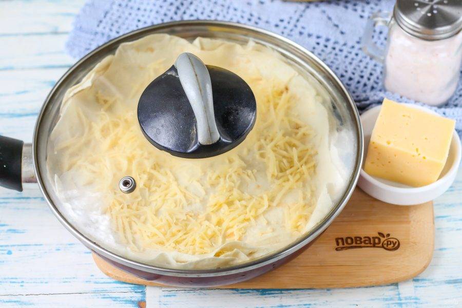 Накройте сковороду крышкой и поместите на плиту, включая минимальный нагрев. Томите пирог до расплавления сыра и до характерного вкусного аромата поджаренной выпечки. Примерно 6-10 минут.