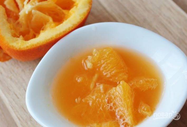 Апельсин вымойте и обсушите. Разрежьте его на две равных половины и ложкой достаньте мякоть, собрав ее и сок в пиалку. 