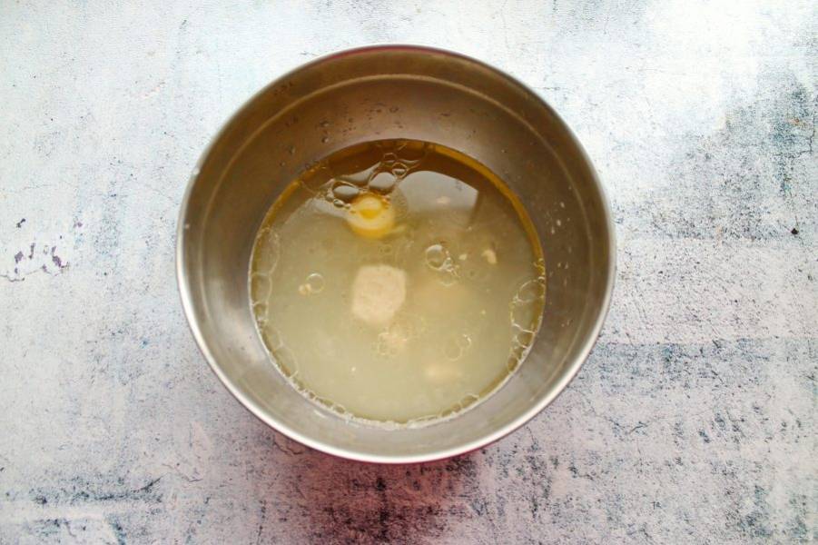 Теплую воду налейте в миску, выложите прессованные дрожжи, соль, сахар и разбейте яйцо. Все хорошо перемешайте до однородности.