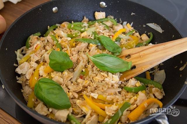 Добавьте листья базилика, перемешайте рис в последний раз, снимите с плиты и выложите на блюдо.