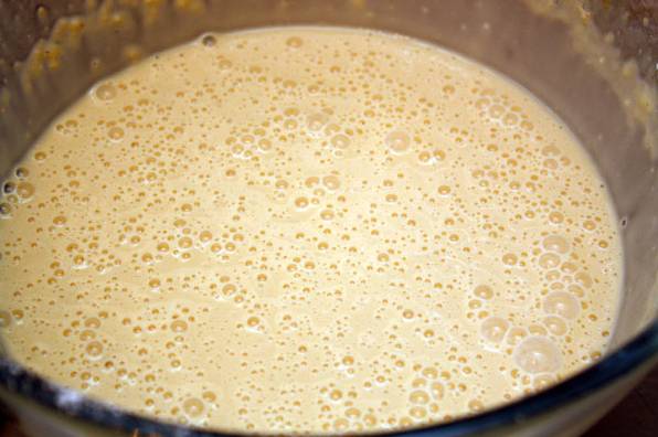 2. Молоко немного нагреть и отправить туда дрожжи. Примерно через 10-15 минут можно влить молоко к яйцам и как следует перемешать. Всыпать понемногу муку, тщательно взбивая. При необходимости влить немного воды, чтобы тесто было жидким. 