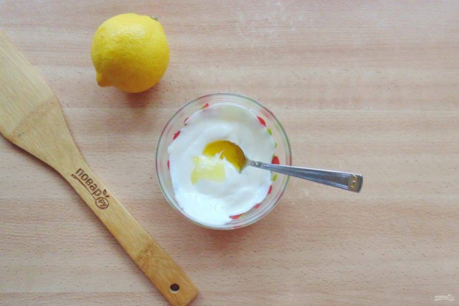 Приготовьте заправку для салата. В миску выложите сметану, добавьте жидкий мёд и лимонный сок по вкусу. Перемешайте эти ингредиенты до однородной консистенции.