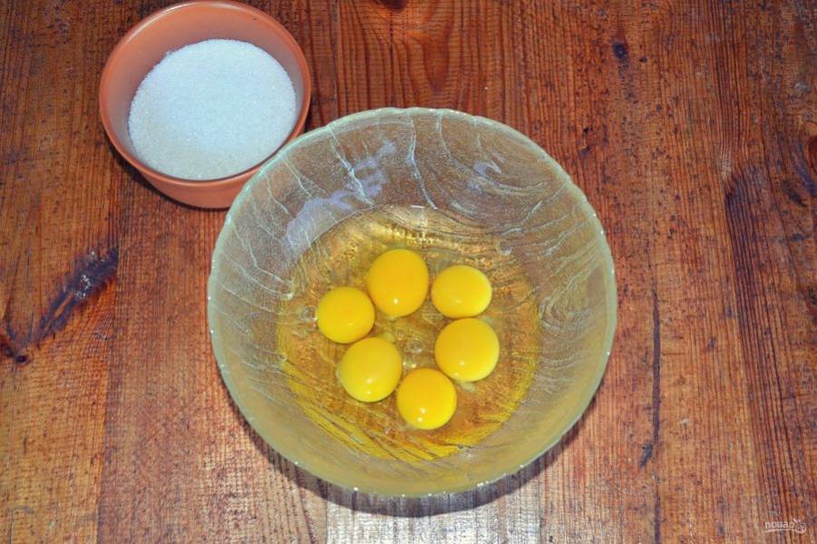 На медленной скорости начните взбивать яйца, постепенно добавляя сахар. 