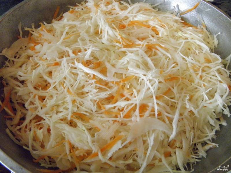Возьмите глубокую сковороду. Влейте растительное масло, разогрейте его. Положите капусту с луком и морковью и обжарьте на среднем огне.