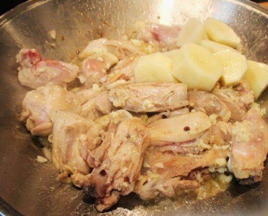 2. Обжариваем курицу в воке или на мелкой сковороде. Жарим на слабом огне со всех сторон до готовности, используя оливковое или растительное масло. В середине жарки добавьте нарезанный картофель и (по вкусу) чеснок. 