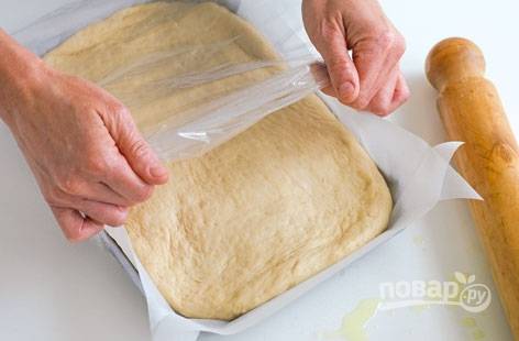 5. Поместите тесто в форму для выпекания, накройте пищевой пленкой и оставьте еще на полчаса.