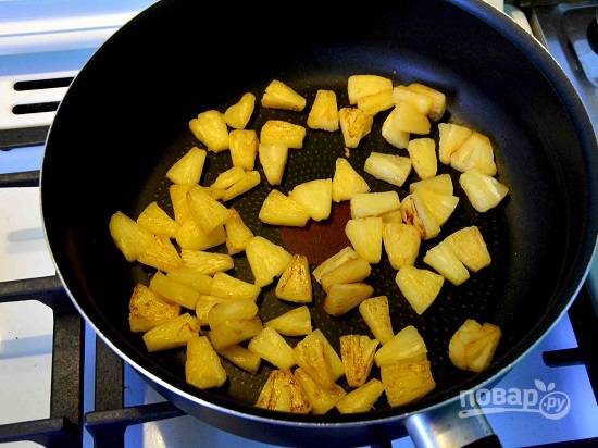 Ананас нарезаем небольшими кусочками и обжариваем на сухой и разогретой сковороде до легкой румяной корочки - карамелизируем ананас. Убираем кусочки ананаса со сковороды.
