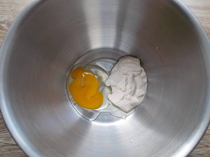 В чашу миксера выложите сметану и разбейте туда яйцо.