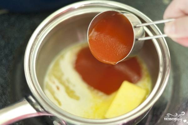 1. В небольшой сотейник отправьте сливочное масло, поставьте его на плиту. Добавьте острый томатный соус. 