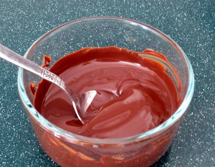 2. Шоколад измельчите, выложите в миску и растопите на водяной бане или в микроволновке. Не забывайте помешивать. Можете добавить немного сливочного масла или несколько ложек жирных сливок.