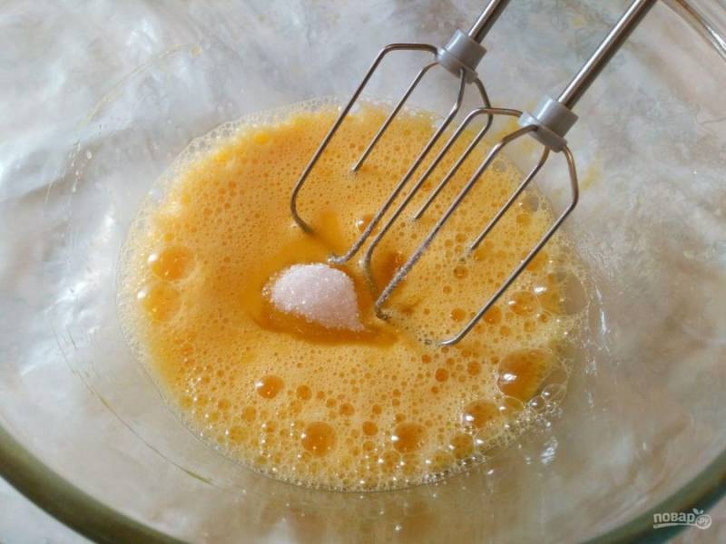 С помощью миксера взбейте яйца до пышности с добавлением сахарного песка, ванильного сахара и щепотки соли. 
