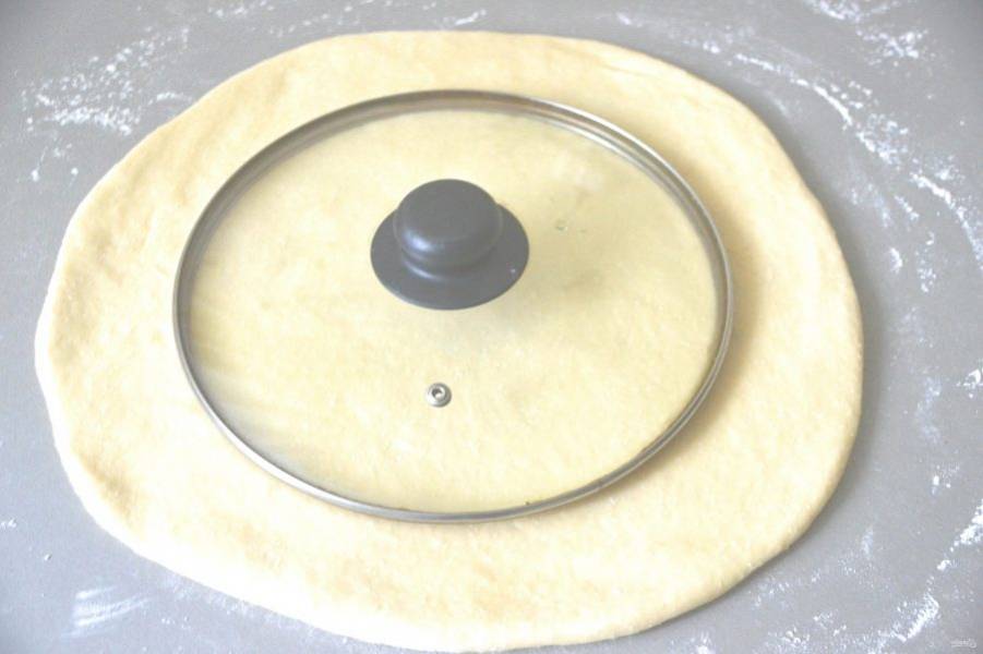 Раскатайте тесто в пласт, диаметр круга должен быть на 4 см. больше диаметра формы. Вырежьте круг диаметром дна формы для выпечки, используйте подручные материалы, например, крышку.