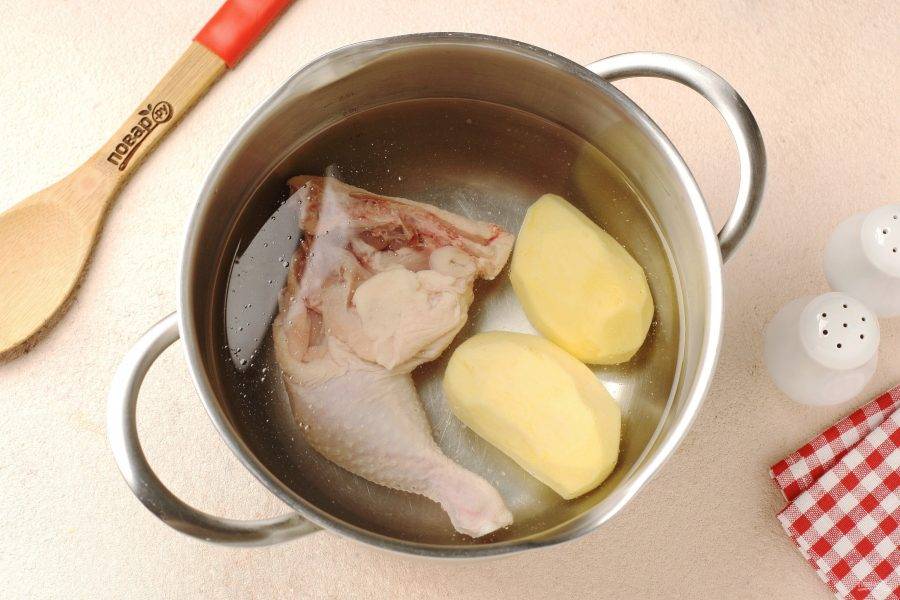 Курицу промойте и переложите в кастрюлю. Добавьте две очищенные картофелины, воду, соль по вкусу и поставьте на плиту. Доведите до кипения, снимите пену и на небольшом огне варите около 30 минут.