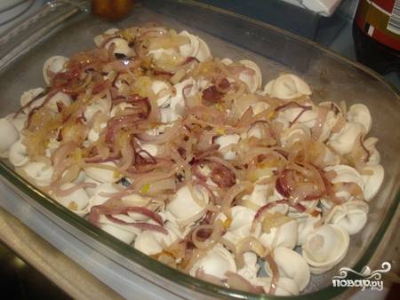 3. Подготовьте жаропрочную форму и смажьте немного маслом. Выложите ровным слоем пельмени и распределите сверху жареный лук. 