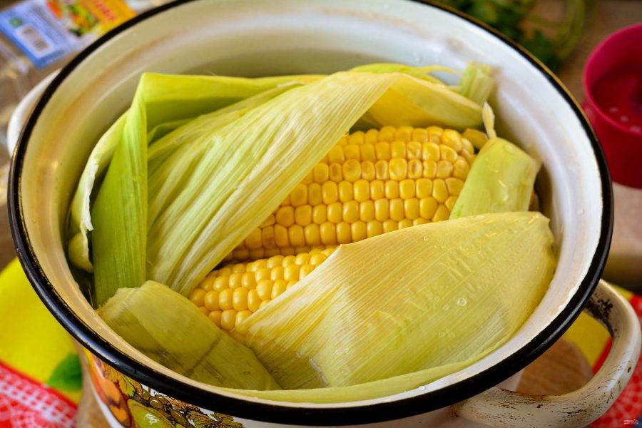 Прикройте кукурузу листьями и залейте полностью водой - воды понадобится примерно 1,5-2 литра. Варите кукурузу до мягкости 30-40 минут. С листьями початки будут более ароматными.