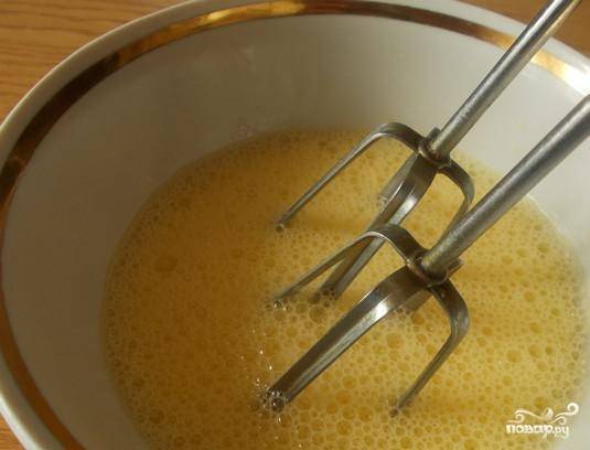 Яйца взбейте в лёгкую пену в миске. Потом добавьте сахар и разотрите смесь до растворения сахара.
