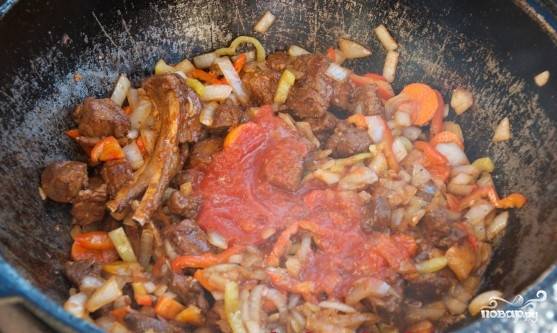 Добавить томатный соус, соль, черный перец, паприку, тмин и красный перец и продолжать смешивать и варить в течение 3-5 мин. Затем добавить чеснок и лавровый лист и варить ещё 20 минут.