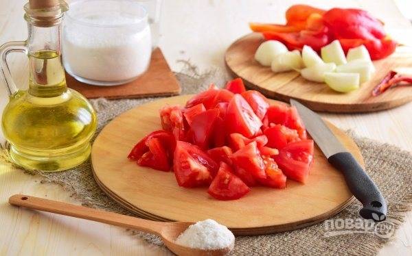 Вымойте помидоры и перцы, достаньте из последнего все косточки. Нарежьте овощи крупными кусками. Лук почистите от шелухи и также крупно нарежьте.