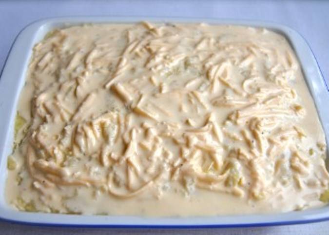 Добавьте в оставшуюся яично-сметанную смесь тертый сыр, перемешайте и вылейте её в форму поверх картофельного пюре. Отправьте в духовку на 20 минут при 220 градусах.