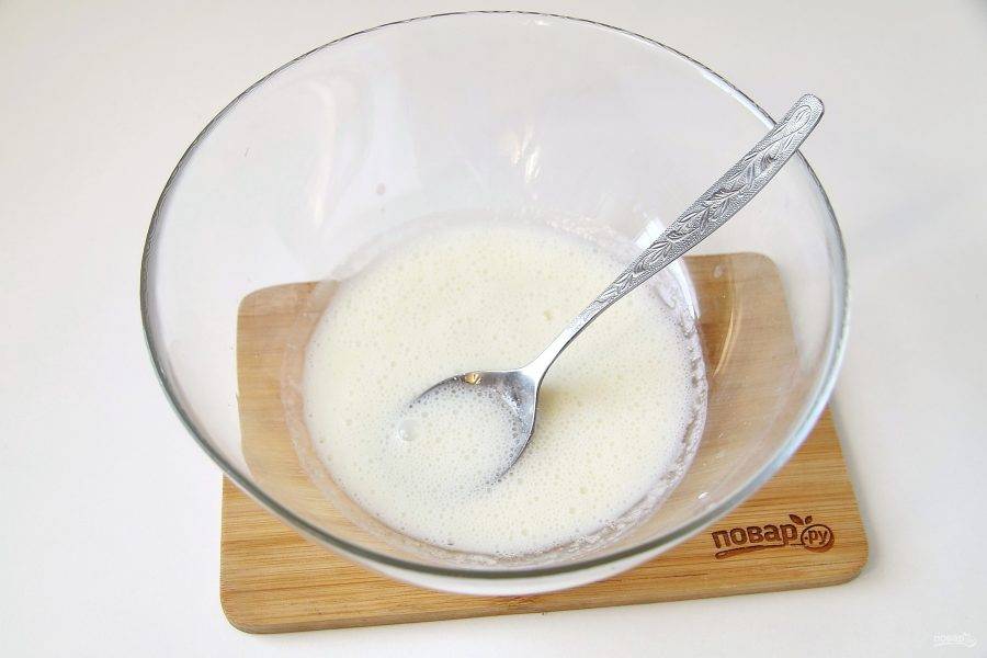 Налейте кефир в глубокую миску. Добавьте сахар, соль, соду и перемешайте до появления пузырьков.