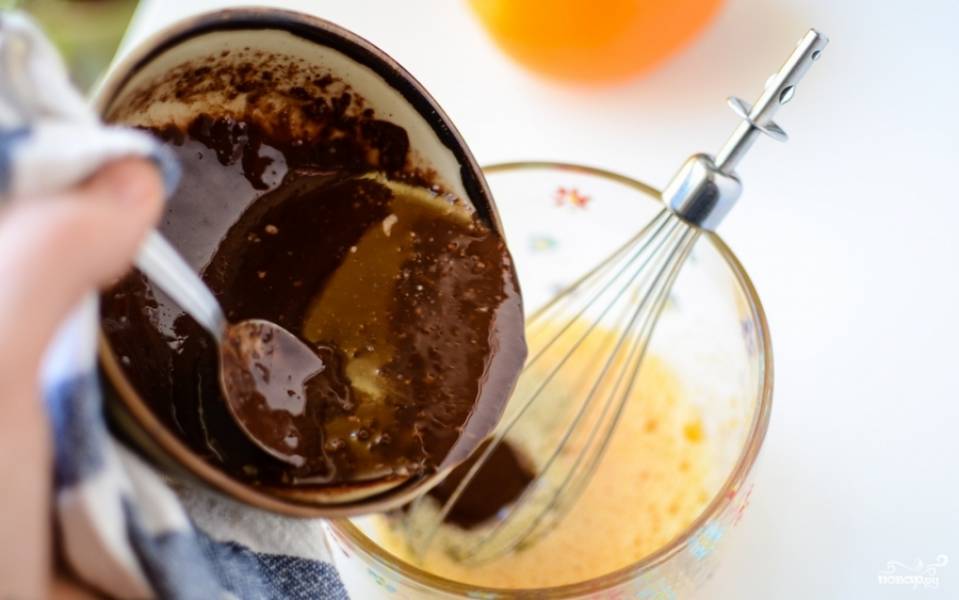 Смешайте вместе топлёный со сливочным маслом тёмный шоколад и взбитое с сахаром яйцо. Добавьте муку и перемешайте.