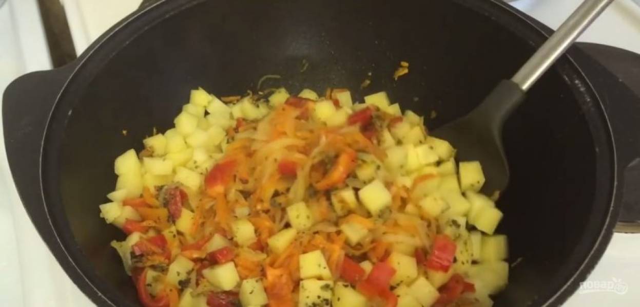 2.  Добавьте смесь специй: базилик, орегано и майоран. Хорошо перемешайте. Добавьте нарезанный кусочками картофель, слегка обжарьте его с овощами, после чего выложите нарезанные кубиками помидоры. Перемешайте. 