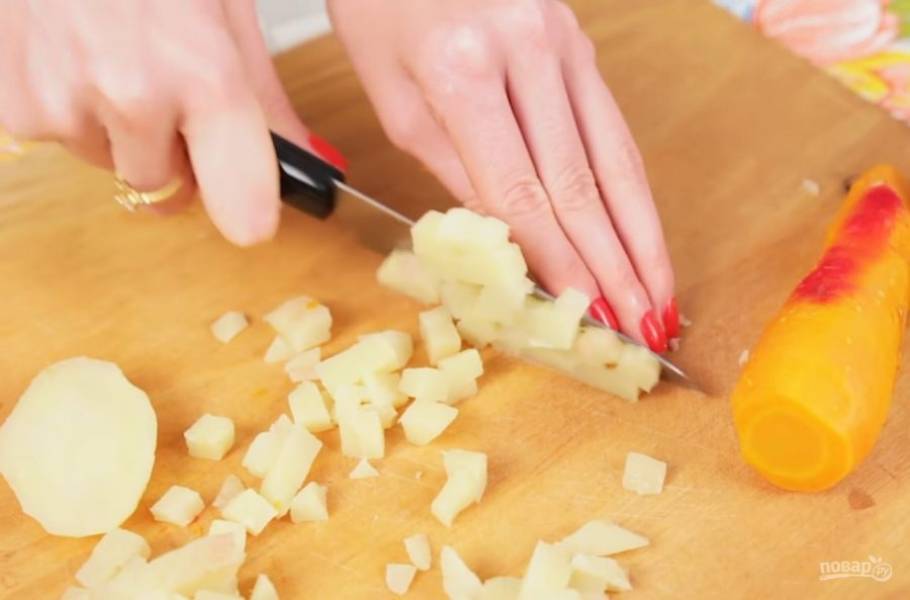 1. Очистите отваренные овощи от кожуры: картофель, морковь и свеклу. Нарежьте мелкими кубиками картофель, затем — морковь. Выложите эти овощи в миску.