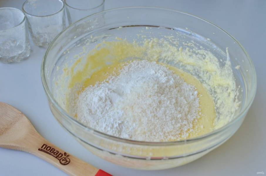 4. Введите просеянную муку, крахмал, разрыхлитель и кокосовую стружку. Миксером доведите тесто до гладкого и однородного состояния. Можно добавить каплю ванильного экстракта или ванильный сахар.

