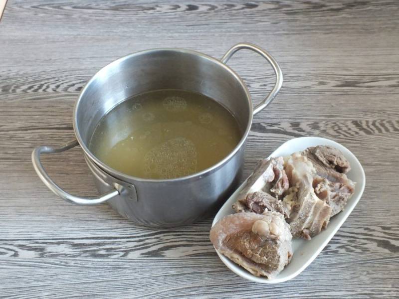 Говяжью косточку вымойте, выложите в кастрюлю и залейте водой. Варите до готовности в течение 1,5-2 часов. После бульон процедите, мясо отделите от кости.