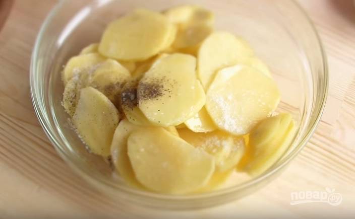 3. Картофель очистите и нарежьте тонкими пластинами. Добавьте оливковое масло, соль, перец. 