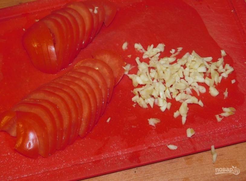 Нарежьте помидоры и измельчите чеснок.