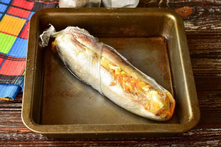 Переложите рыбу в форму для выпекания, на дно которой налейте стакан воды.