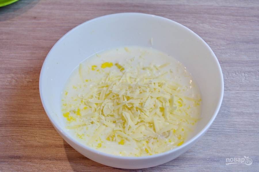 В миске смешайте 150 мл молока, 2 яйца, 150 граммов натертого на крупной терке твердого сыра (у меня "Детский"). Добавьте немного соли и перца.