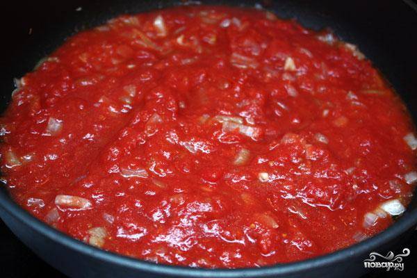 Когда лук и чеснок зазолотятся - заливаем их томатным пюре. Доводим смесь до кипения, после чего на медленном огне прогреваем еще 5-7 минут.
