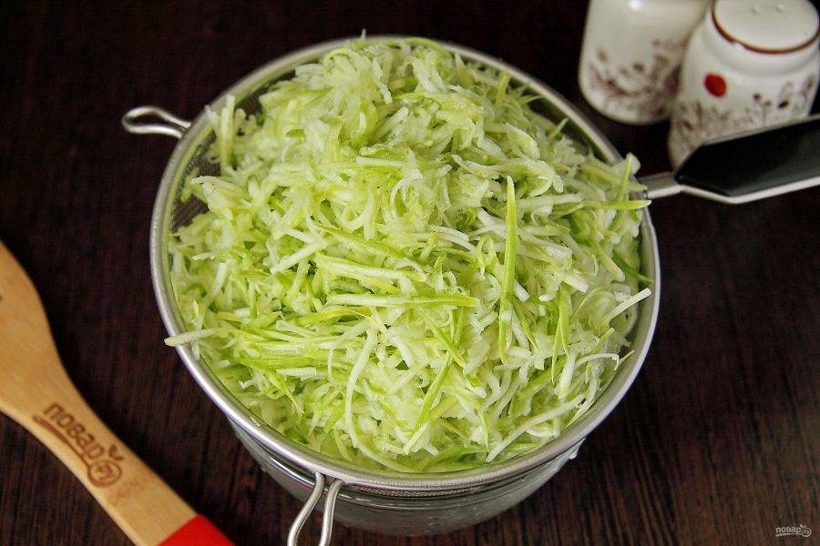 Добавьте к тертым кабачкам щепотку соли и оставьте на 10 минут, после чего отожмите хорошо руками от выделившегося овощного сока.